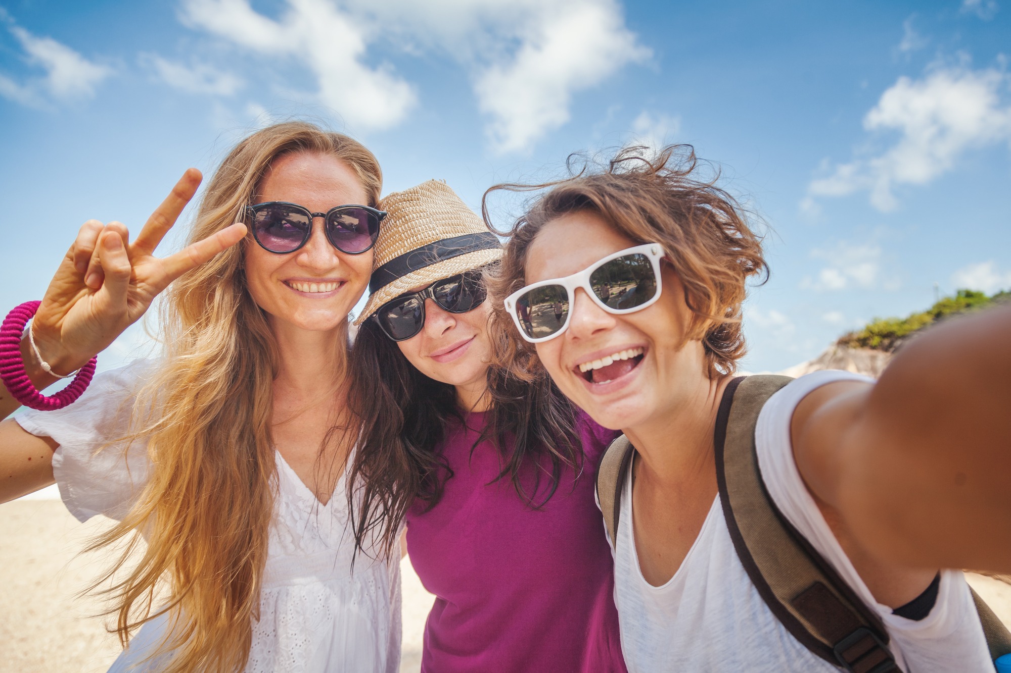 Young beautiful woman doing selfie on the beach. Friendship, freedom, travel.